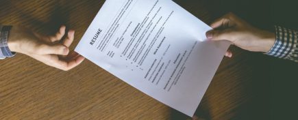 top overhead directly above view of employee hiring person and examine the resume on the office table