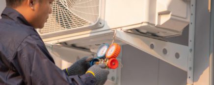 Technician use measuring equipment for filling air conditioners.